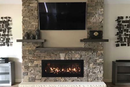 A fireplace with a tv mounted above it