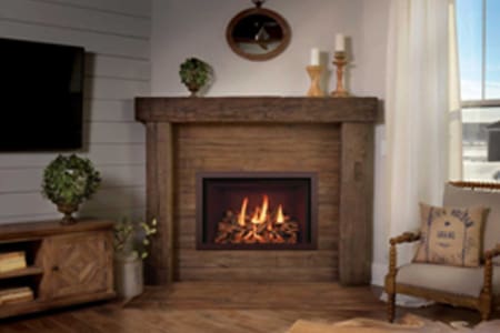 A fireplace in the corner of a room with wood paneling.